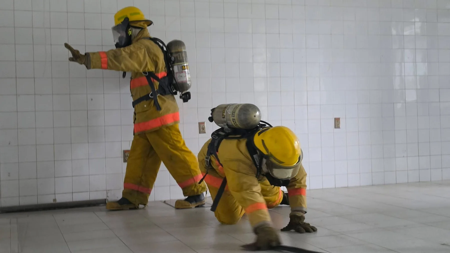 Participantes con equipo de protección respiratoria y trajes para incendio